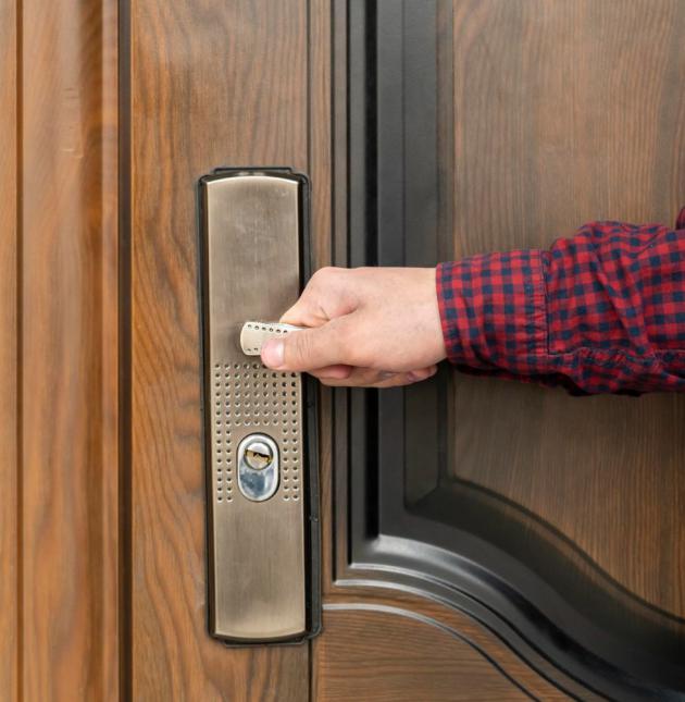 Hand öffnet die Tür zur Wohnung